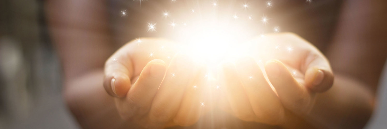 Zwei Hände halten schützend ein leuchtendes Licht – ruhig und symbolisch.