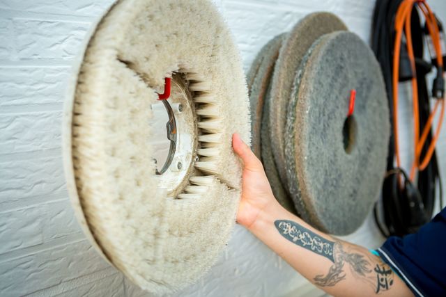 Eine Person hält eine Schleifscheibe in der Hand.